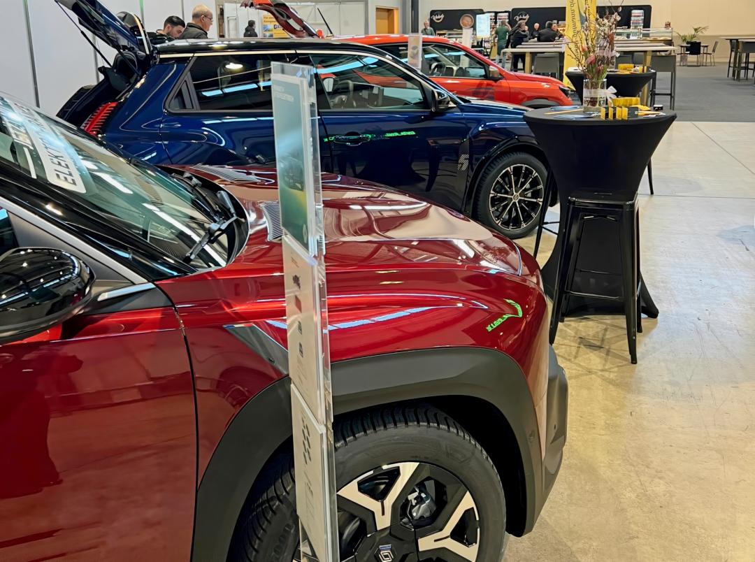 Mehrere ausgestellte Fahrzeuge in Rot, Blau und Orange am Messestand des Autohauses Gutmann auf der GETEC-Messe.
